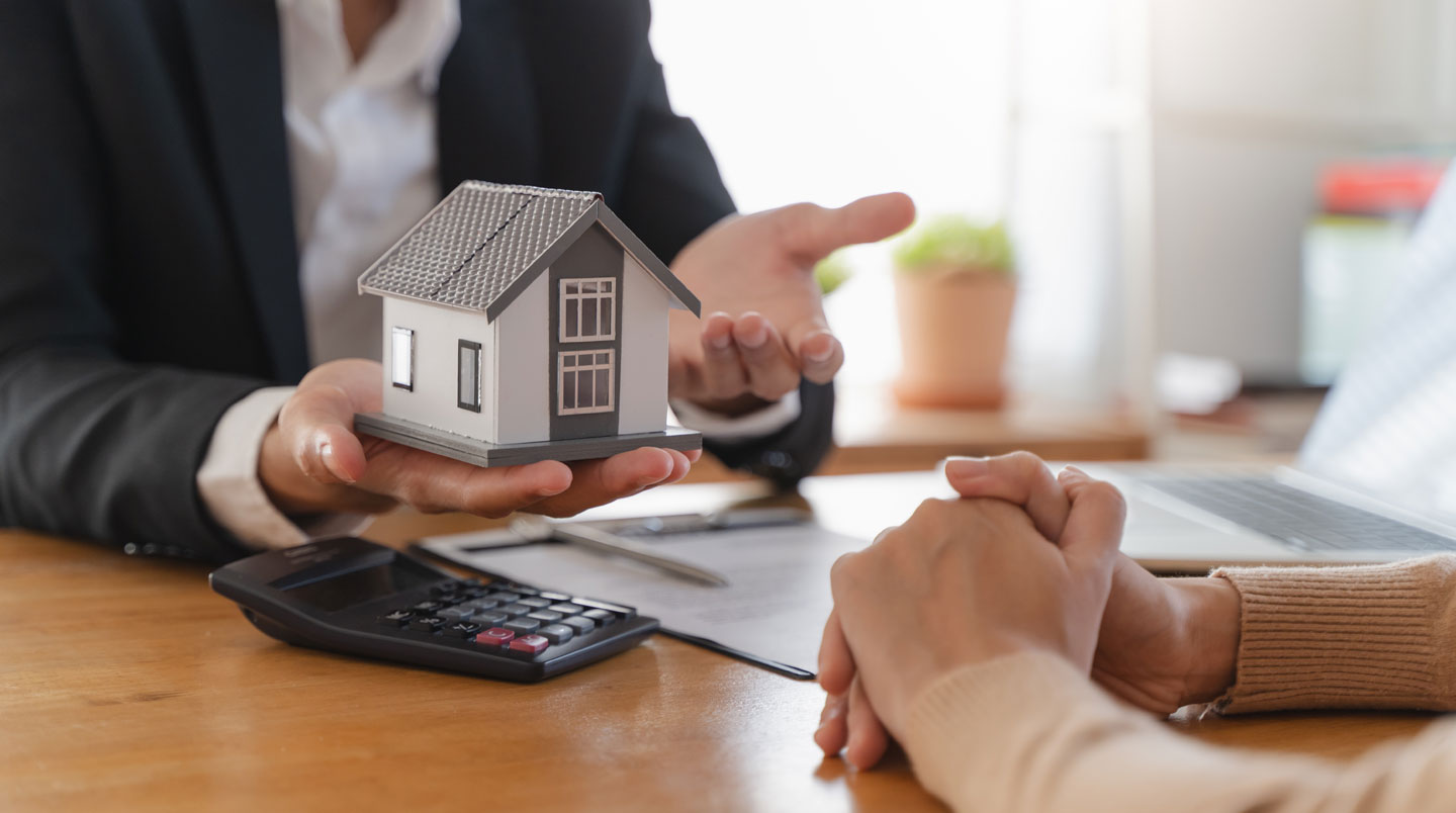 Couple trentenaire consultant des documents immobiliers devant une résidence contemporaine à Lyon